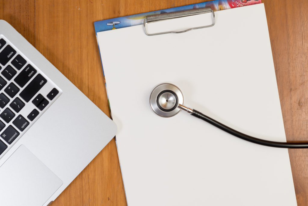 stethoscope on paper next to laptop