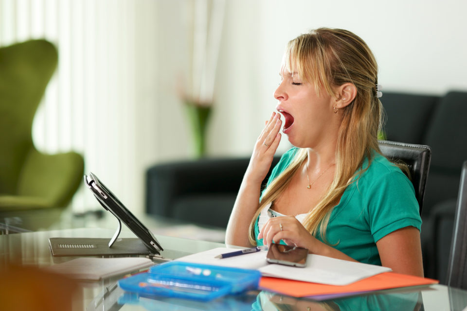 Young Woman Yawning While Studying